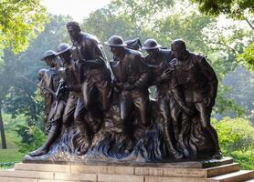 A statue of a group of men standing on a hill photo