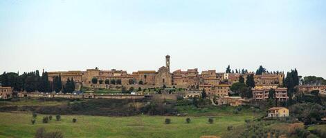 A large building with a clock tower on top of a hill photo