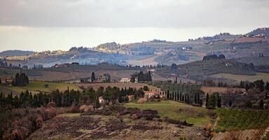 A view of a hillside with a house and trees photo