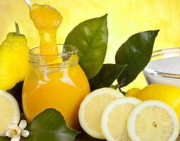 A jar of lemon juice with lemons and other ingredients photo