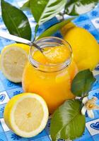 A jar of lemon juice with a spoon on a table photo