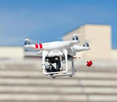 A white drone flying over a building photo
