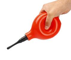A person holding a red plastic tube with a black handle photo