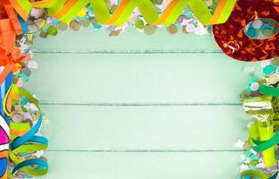 Colorful confetti and streamers on a wooden background photo