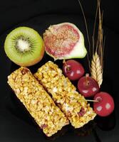 A plate with a bunch of fruit and cereal bars photo