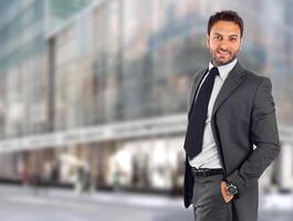 A man in a suit standing in front of a building photo
