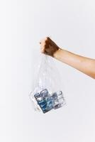 Man holding a bag filled with plastic bottles on a white background with space for text photo