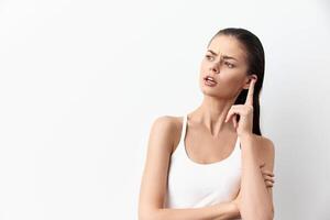 thoughtful woman with an inquisitive expression standing against a plain white background, her hand photo