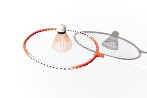 Orange and white badminton racket and shuttlecock casting a shadow on a white surface. photo