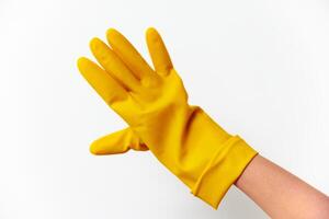 Rubber gloves in yellow color being worn on hands of a person, isolated on white background. photo