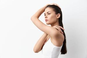 A side profile of a young woman with long, straight hair, dressed in a simple white top She exudes photo