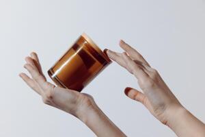 Hand holding cup of brown liquid on white background, with copy space above cup. image perfect for photo