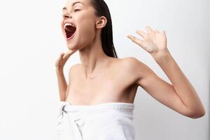 Enthusiastic young woman with wet hair and a towel, expressing joy with an open mouth and dynamic photo