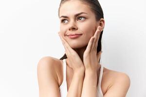 Close up of a lovely young woman with a serene expression, gently holding her face The image photo