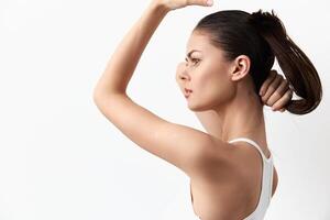 This image captures a young woman with a sleek ponytail in a side profile, exuding poise and photo