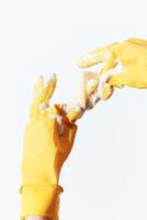 Yellow rubber gloves held by hands on white background. photo