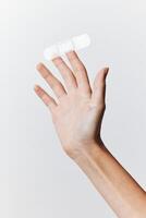 Adhesive bandage being held in hand against a white background, with a part of the bandage sticking photo