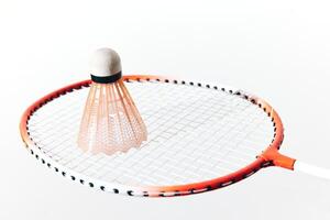 Orange badminton racket and shuttlecock on a white background. 3d ing. photo
