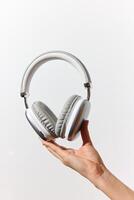 Headphones held in hand on white background with space for text. photo