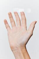 Band-aid in hand on white background, another band-aid visible on hand. concept of first aid and photo