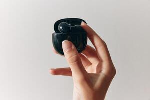 Person comparing two types of earbuds on white background. concept of choice, technology, sound photo