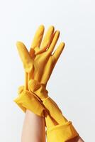 Yellow rubber gloves on hand isolated on white background with copy space. a concept of cleaning or photo