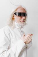 modern futuristic model with long white hair and sleek sunglasses posing against a plain white photo