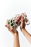 Hand holding knitted bag with green and red apples on white background. photo