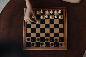 Person engaging in an intense game of strategy on a wooden table with a classic black and white photo