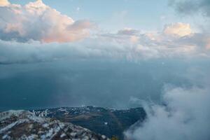 Serene Ocean View from a Majestic Mountain Summit with Fluffy Clouds in the Sky photo