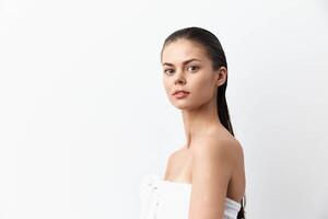 Captivating image of a young woman with sleek wet hair, standing confidently against a clean white photo