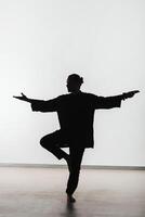 Silhouette of a person practicing qigong energy exercises on a light background photo