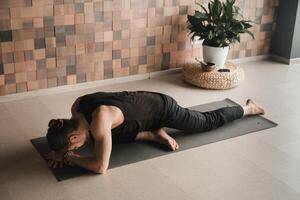 A man performing gymnastic exercises on a yoga mat at home photo