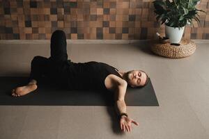 A man performing gymnastic exercises on a yoga mat at home photo