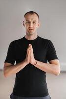 An athletically built man does yoga in the gym on a mat photo