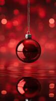 Red Christmas ornament reflecting on water with bokeh background. photo