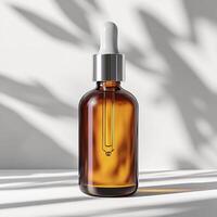 Amber glass dropper bottle with silver lid, perfect for beauty products, isolated on light background. photo