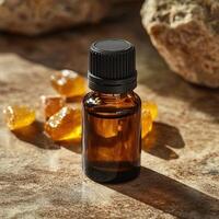 Essential oil bottle on a textured surface, surrounded by amber resin pieces. photo