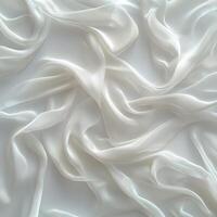 Delicate white silk fabric draped elegantly on white background, creating a soft and flowing texture. photo