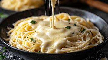 Creamy cheese sauce drizzled over fresh pasta in a rustic bowl. photo