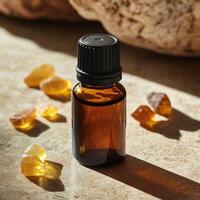 Essential oil bottle with amber glass, surrounded by resin pieces, natural light highlights the scene. photo