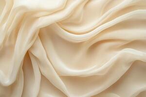 Elegant soft fabric draping in waves, showcasing a creamy beige color and smooth texture. photo