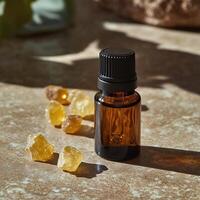 Essential oil bottle with resin chunks, artistic warm background. photo