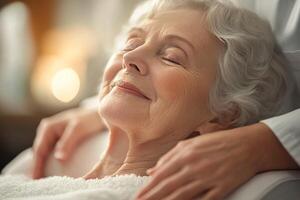 Senior woman enjoying a relaxing spa treatment, serene expression, hands gently massage her shoulders. photo