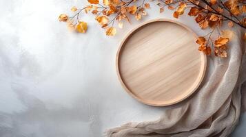 Wooden plate surrounded by autumn leaves and fabric, elegant composition for seasonal dining or decorating. photo