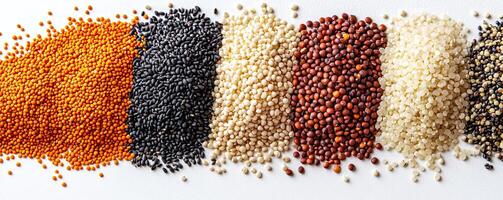 Assorted seeds in various colors arranged on white background. photo