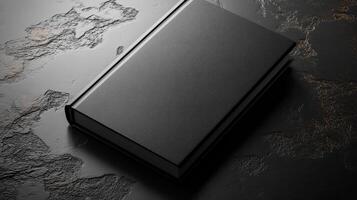 Minimalist black notebook lying on a textured surface, perfect for design enthusiasts and writers. photo