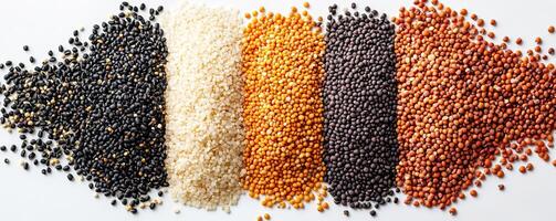 Colorful variety of uncooked grains and seeds arranged on a white background. photo