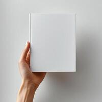 A woman hand holding a white magazine on a white background photo