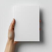 A woman hand holding a white magazine on a white background photo